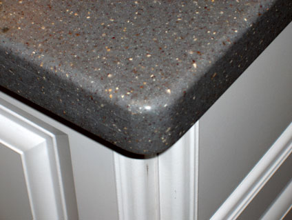 gray corian countertop on white kitchen cabinet